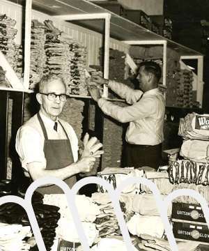 Vintage factory workers organizing products inside a manufacturing facility in 1987